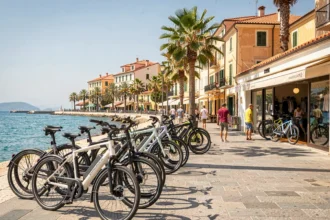 Vue panoramique d'un magasin de vélos électriques sur la promenade côtière des Alpes-Maritimes avec palmiers et architecture méditerranéenne